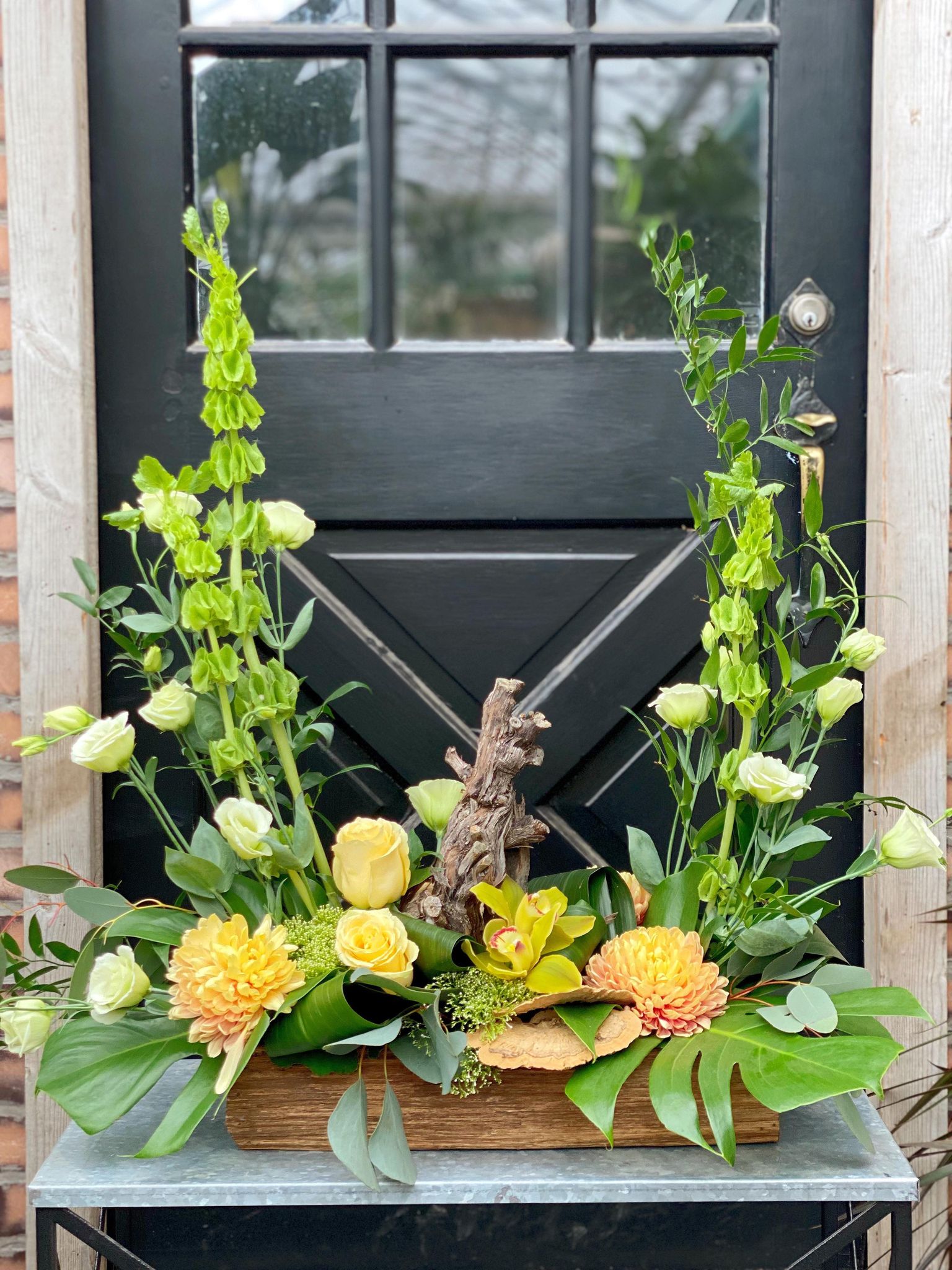 The Watering Can | A large oblong European style arrangement that spreads outwards and upwards on each end.