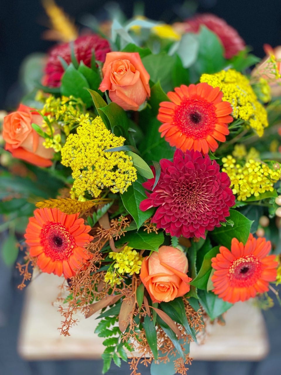 The Watering Can | View from above of a lush yellow, orange, and red bouqet.