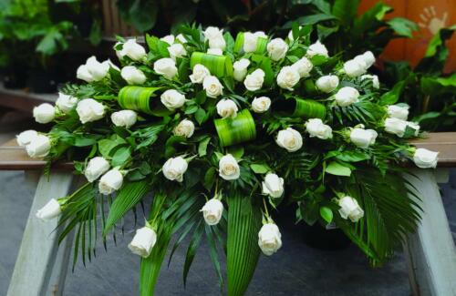 The Watering Can | A white rose casket spray.