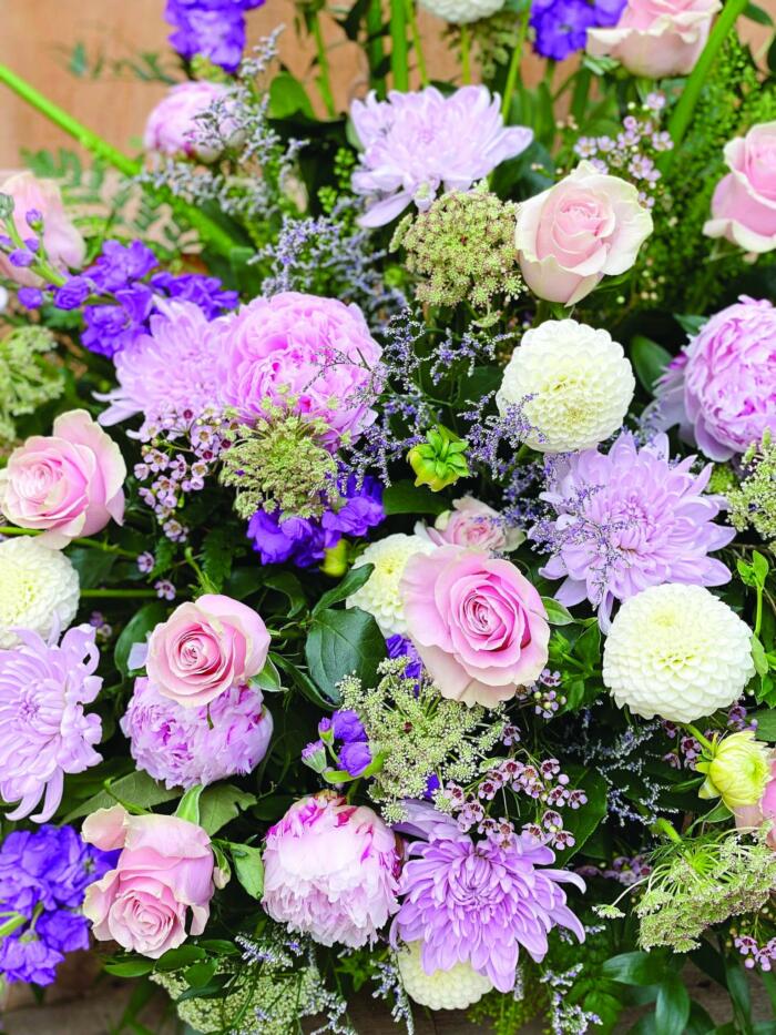 The Watering Can | Close up of some soft pink peonies, lavender mums, white dahlias, and soft pink roses in a side spray.