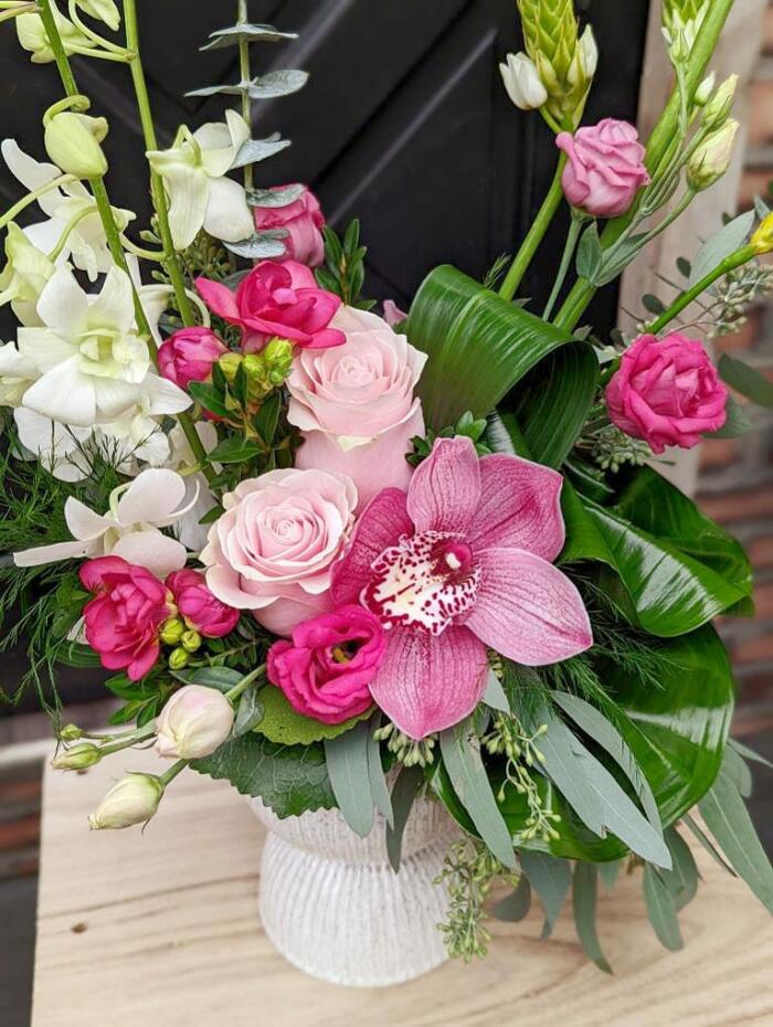 The Watering Can | A tall pink European style floral arrangement in a white ceramic pedestal vase.