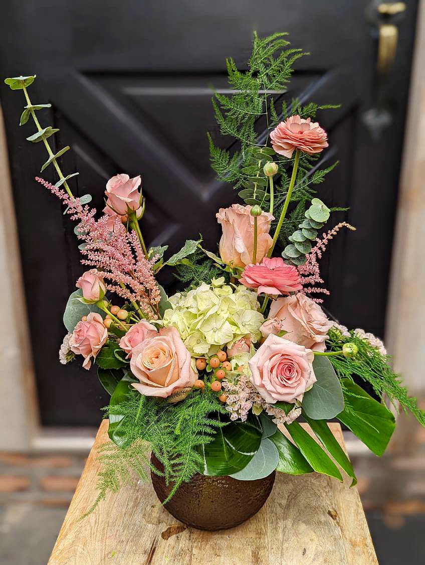 The Watering Can | A peach and pink bouquet in round vase.