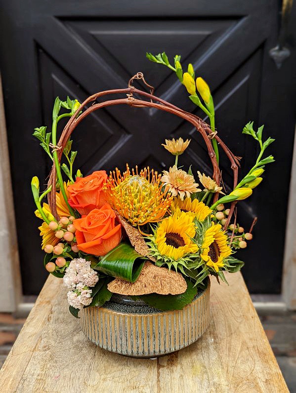 The Watering Can | A yellow and orange European style floral arrangement.