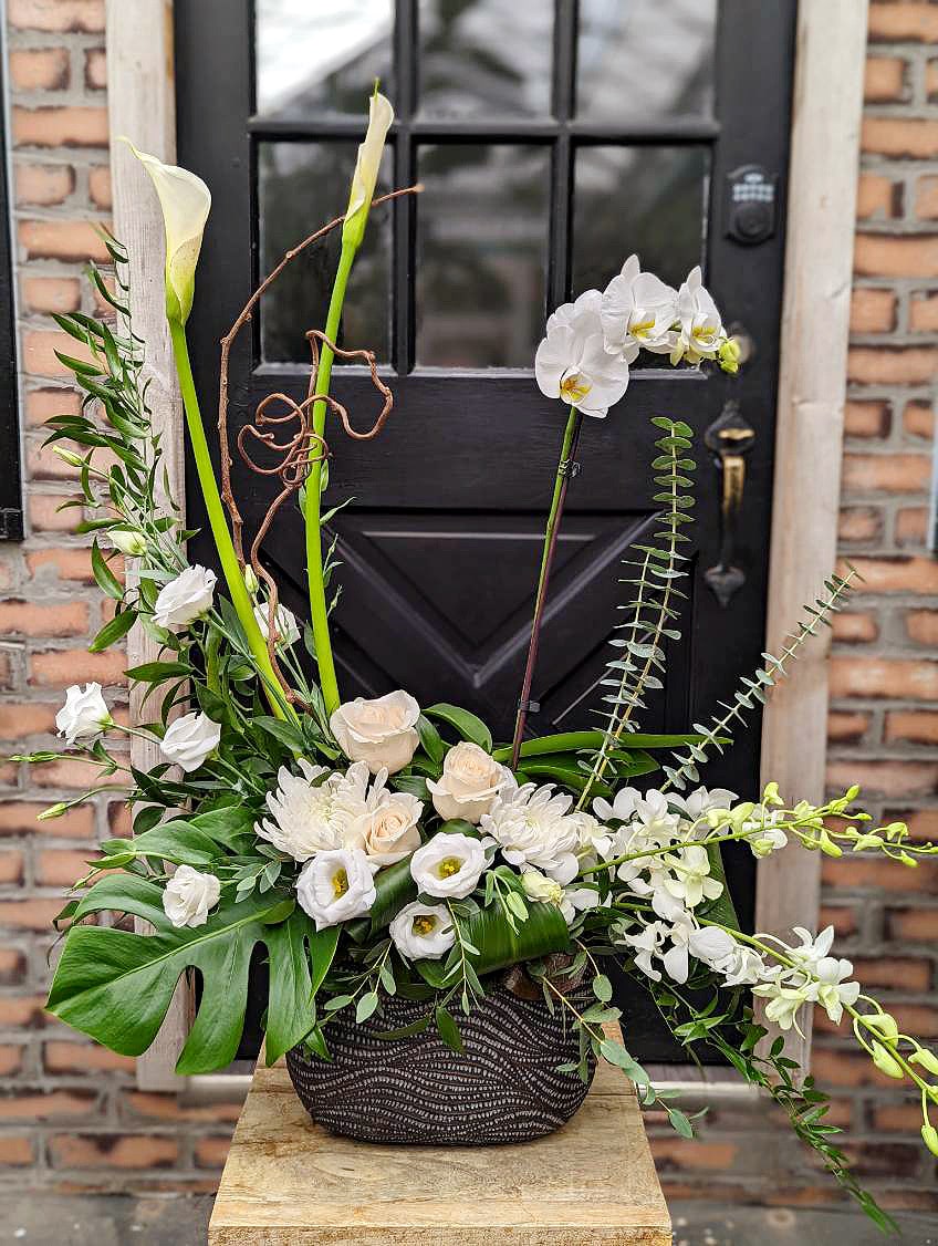 The Watering Can | A large white European style arrangement in a black oval container.