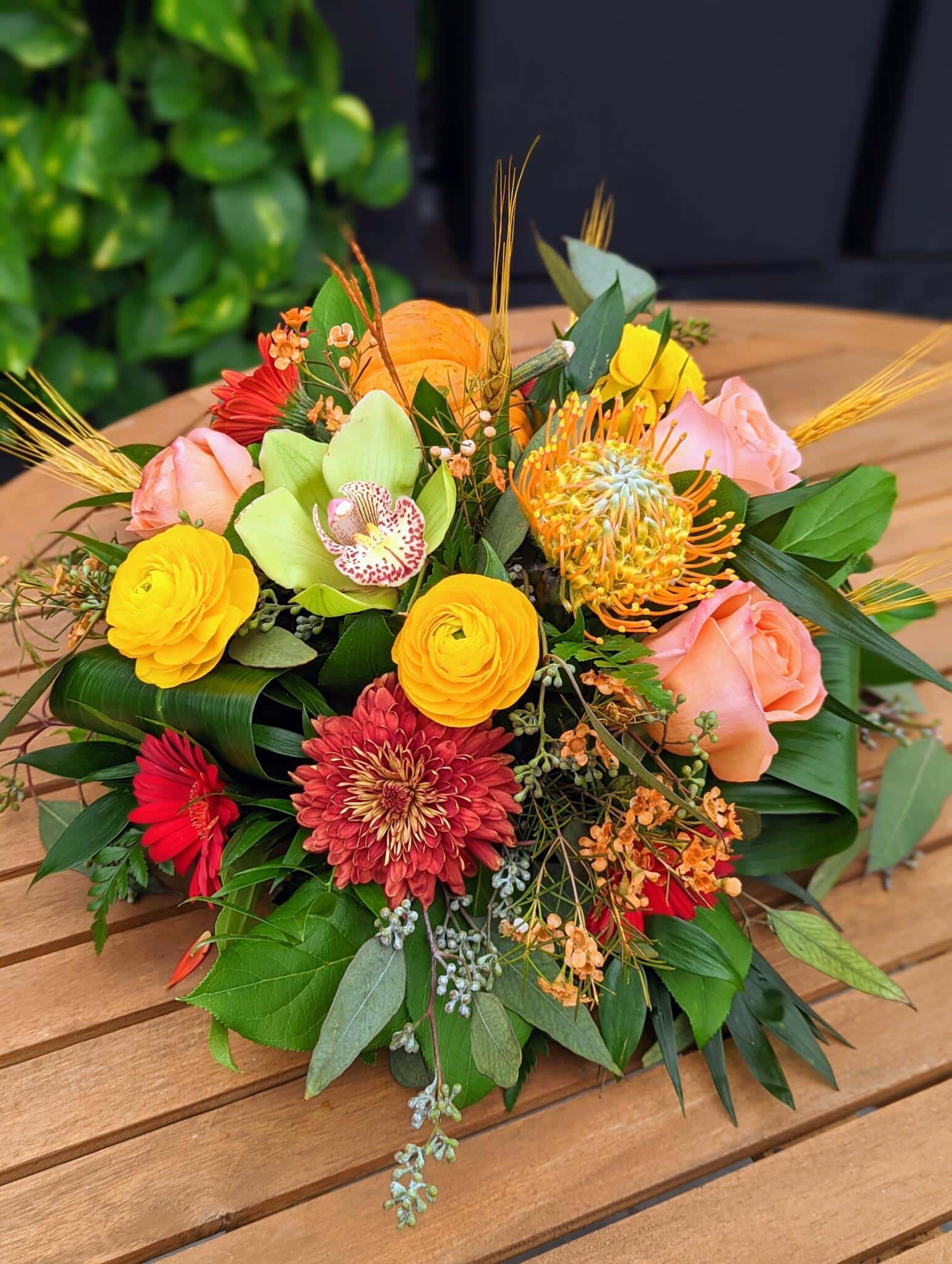 The Watering Can | A citrus coloured table centerpiece with dired wheat accents.