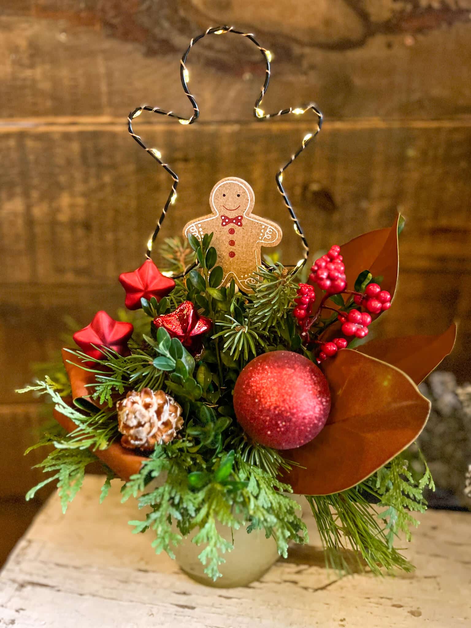 The Watering Can | This kit features a ceramic pot filled with festive winter greenery and decorations. It also has a light up gingerbread silhouette and a gingerbread man decor.