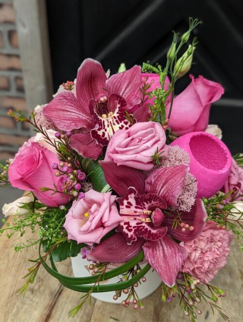 The Watering Can | A hot pink European style arrangement in a white ceramic container.